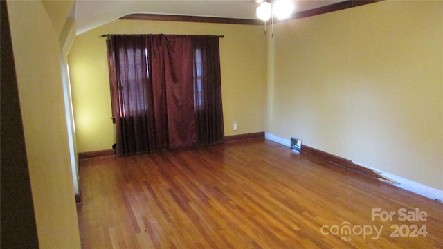 spare room with ceiling fan, wood-type flooring, and lofted ceiling