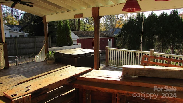 wooden terrace with a hot tub and ceiling fan