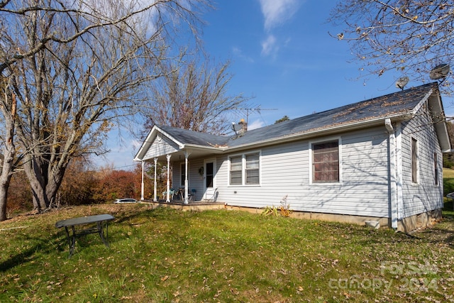 rear view of property with a lawn