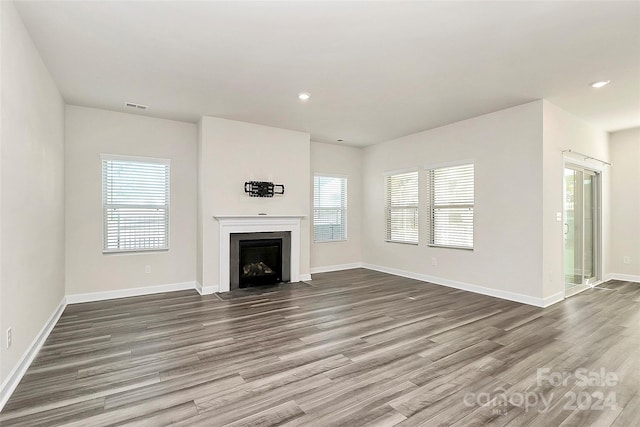 unfurnished living room with hardwood / wood-style flooring and plenty of natural light