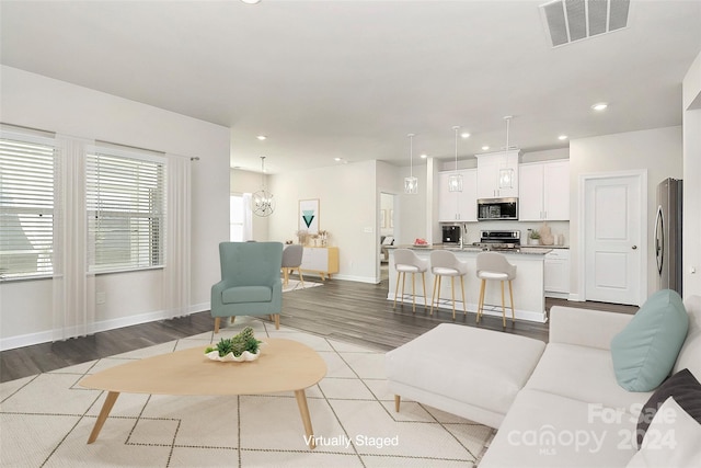 living room featuring light hardwood / wood-style flooring and a notable chandelier