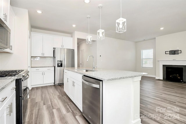 kitchen featuring white cabinetry, appliances with stainless steel finishes, sink, and a kitchen island with sink