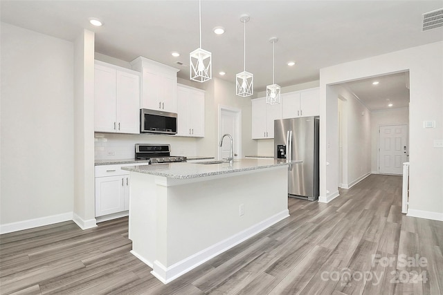 kitchen with sink, stainless steel appliances, white cabinets, light hardwood / wood-style flooring, and a kitchen island with sink