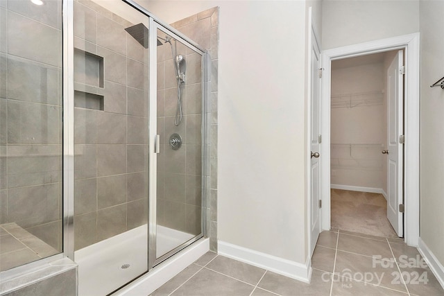 bathroom featuring tile patterned floors and a shower with shower door