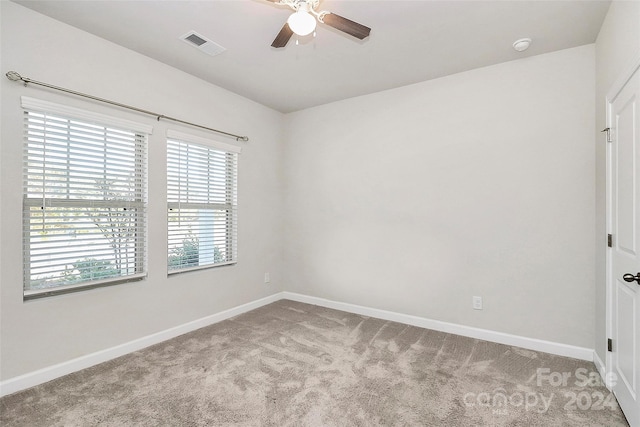 carpeted spare room with ceiling fan