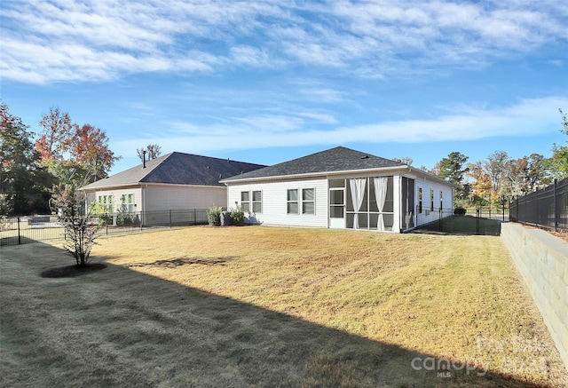 rear view of property with a yard and a sunroom