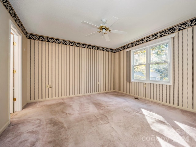 spare room with ceiling fan, a textured ceiling, and light colored carpet