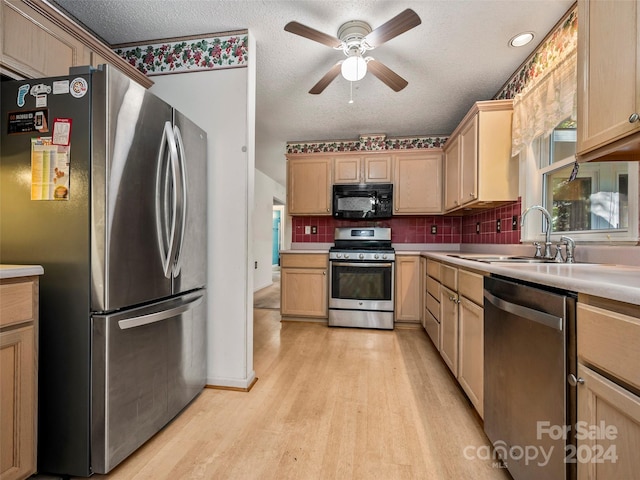 kitchen featuring light brown cabinets, tasteful backsplash, sink, light hardwood / wood-style floors, and stainless steel appliances