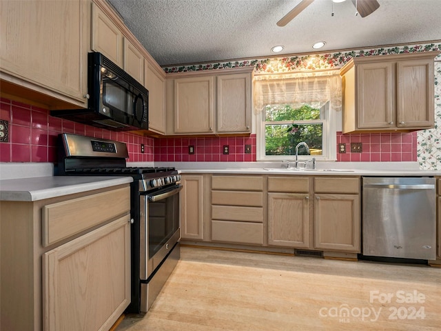 kitchen with a textured ceiling, stainless steel appliances, light hardwood / wood-style floors, and tasteful backsplash