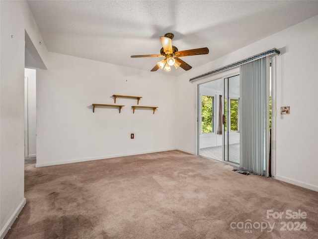 carpeted empty room featuring a textured ceiling and ceiling fan