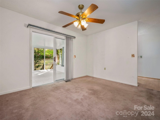 carpeted empty room featuring ceiling fan