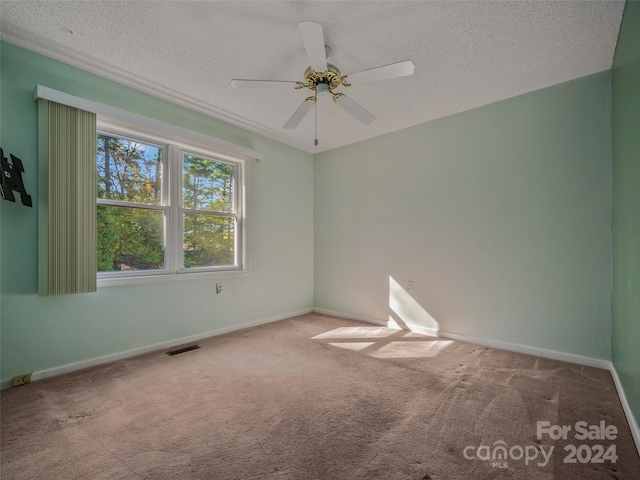 carpeted empty room with ceiling fan and a textured ceiling