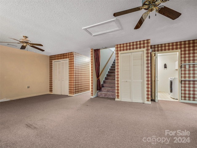 unfurnished living room featuring carpet flooring, washer / clothes dryer, a textured ceiling, and ceiling fan