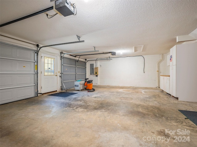 garage with a garage door opener and electric panel