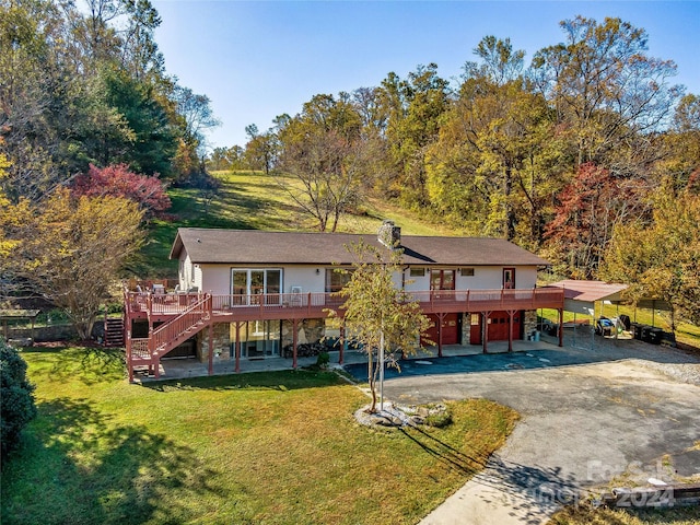 back of house with a wooden deck, a yard, and a carport