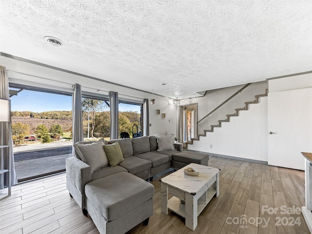 living room with a textured ceiling and light wood-type flooring