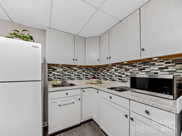 kitchen featuring white cabinets, tasteful backsplash, sink, and white refrigerator