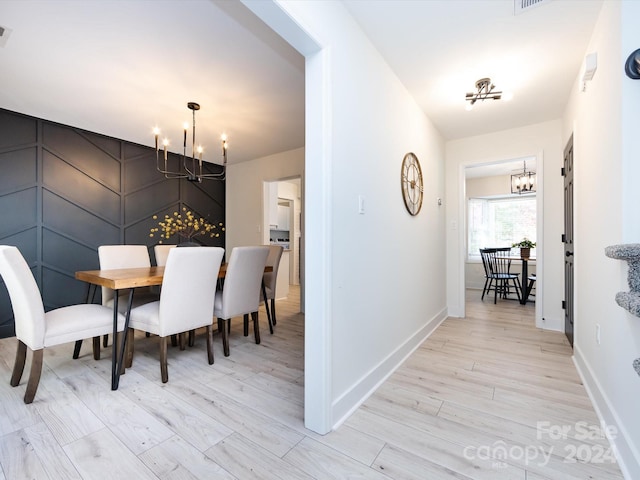 dining room with light hardwood / wood-style flooring and a chandelier