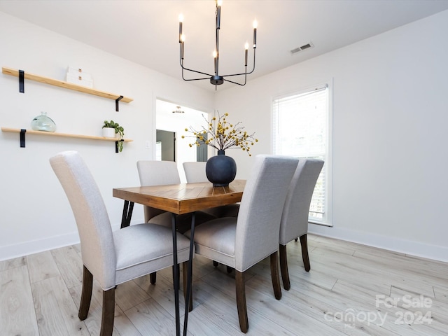 dining space featuring a notable chandelier and light wood-type flooring