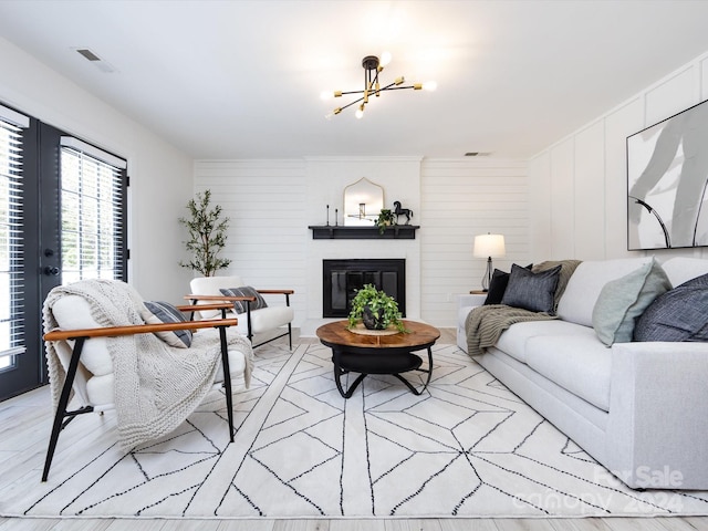 living room featuring a notable chandelier and light wood-type flooring