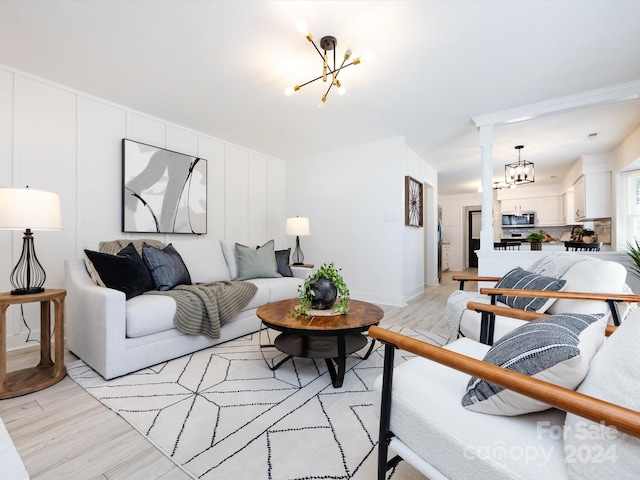 living room with light hardwood / wood-style floors and an inviting chandelier