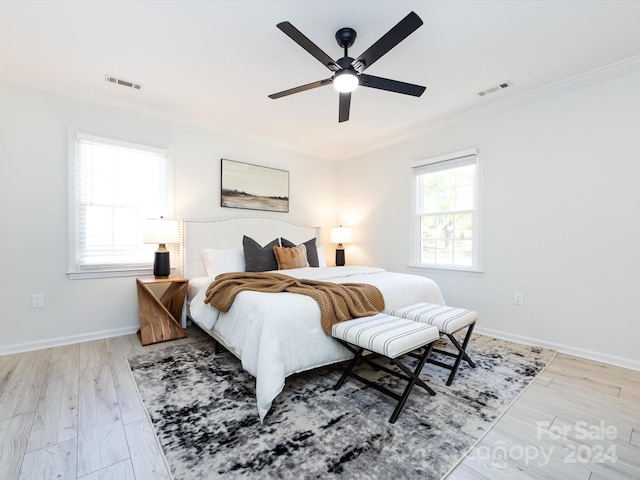 bedroom featuring light hardwood / wood-style flooring, crown molding, and ceiling fan