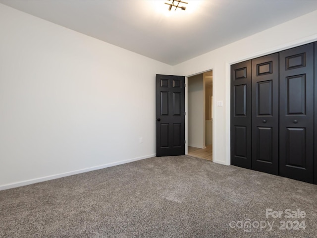 unfurnished bedroom with a closet and carpet floors