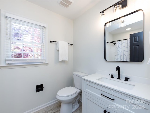 bathroom featuring vanity, toilet, curtained shower, and hardwood / wood-style floors