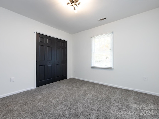 unfurnished bedroom with a closet and carpet floors