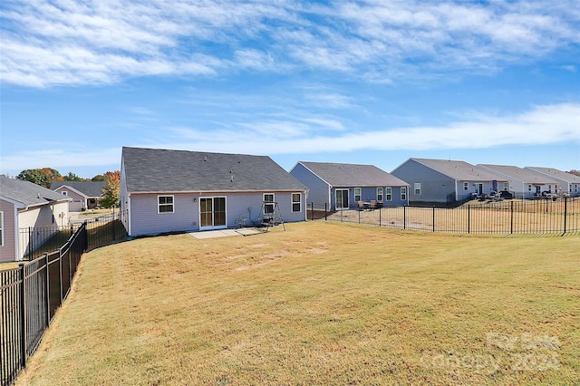 rear view of property featuring a patio and a lawn