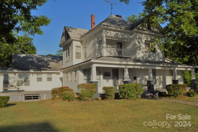 back of house featuring a yard and a balcony