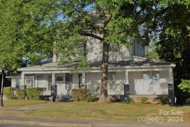 view of front of property with a porch and a front lawn