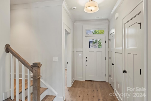 entrance foyer with crown molding and light wood-type flooring