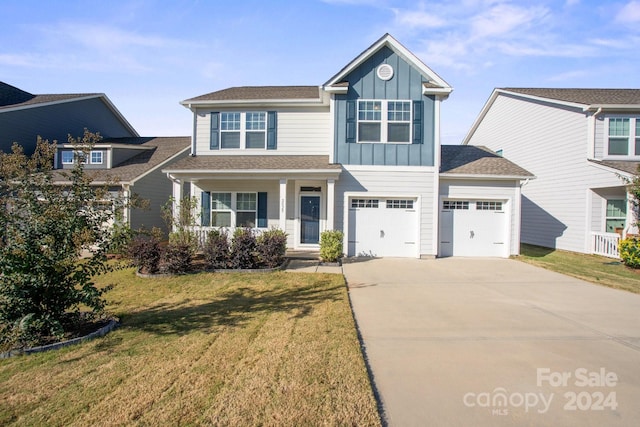 view of front of house featuring a porch, a front yard, and a garage