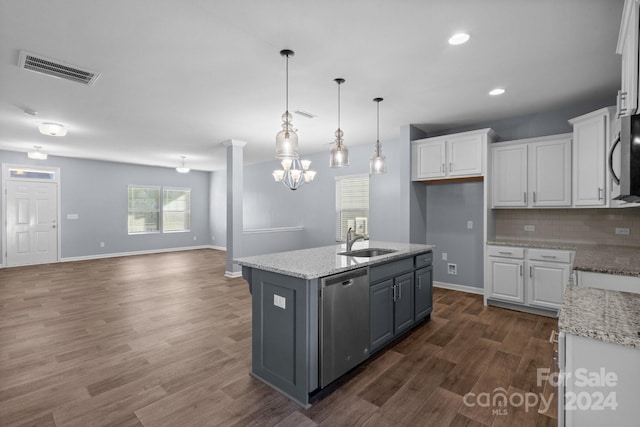 kitchen with appliances with stainless steel finishes, sink, white cabinetry, light stone counters, and a kitchen island with sink