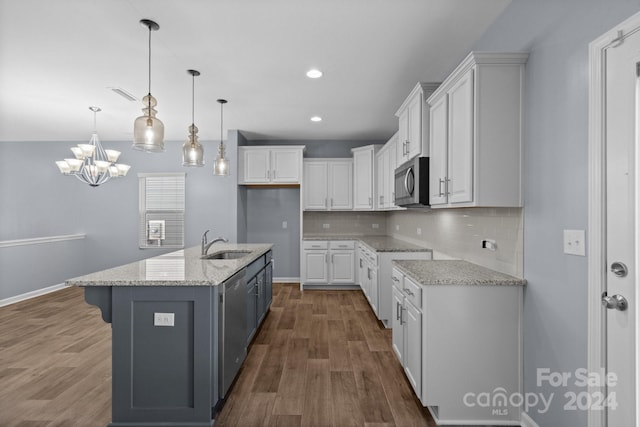 kitchen featuring sink, stainless steel appliances, white cabinets, dark wood-type flooring, and a kitchen island with sink