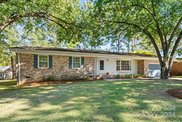 ranch-style house featuring a garage and a front lawn