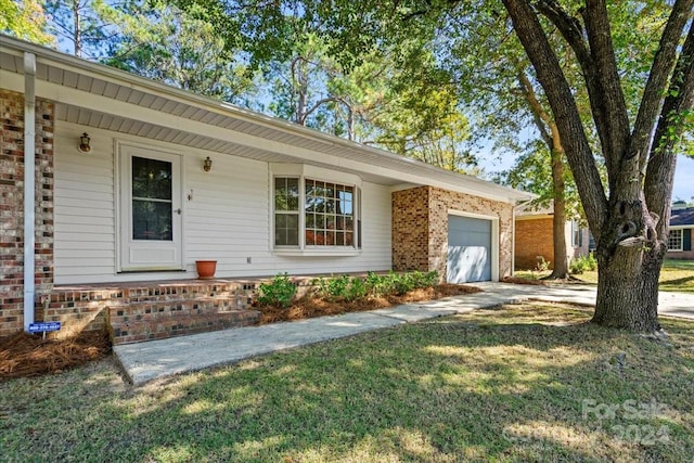 ranch-style house featuring a front lawn and a garage