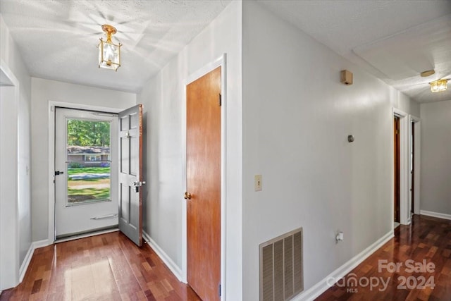 entryway with a textured ceiling and dark hardwood / wood-style floors