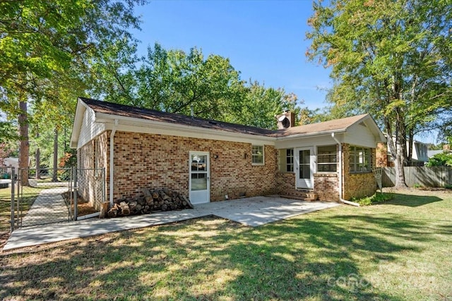 rear view of house with a patio and a lawn