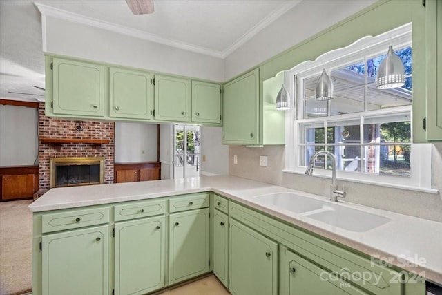 kitchen with green cabinetry, kitchen peninsula, sink, and crown molding