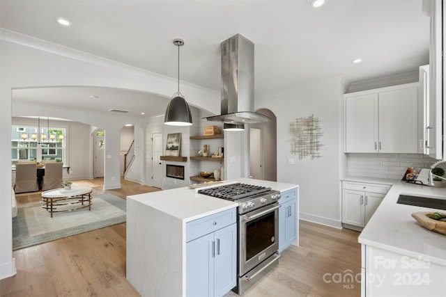 kitchen with island range hood, stainless steel range, and white cabinets