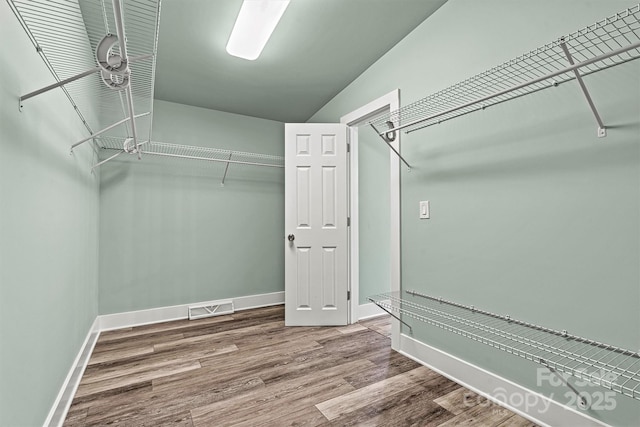 spacious closet with hardwood / wood-style flooring