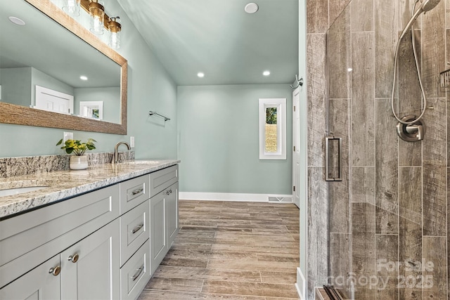 bathroom with vanity, a shower with shower door, and hardwood / wood-style flooring