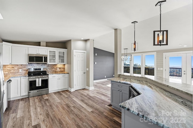 6230 Pine Ridge Dr, Connelly Springs, NC 28612 - kitchen featuring light wood finished floors, light stone countertops, tasteful backsplash, appliances with stainless steel finishes, and lofted ceiling