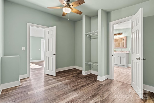 6230 Pine Ridge Dr, Connelly Springs, NC 28612 - unfurnished bedroom featuring a closet, a sink, a ceiling fan, wood finished floors, and baseboards