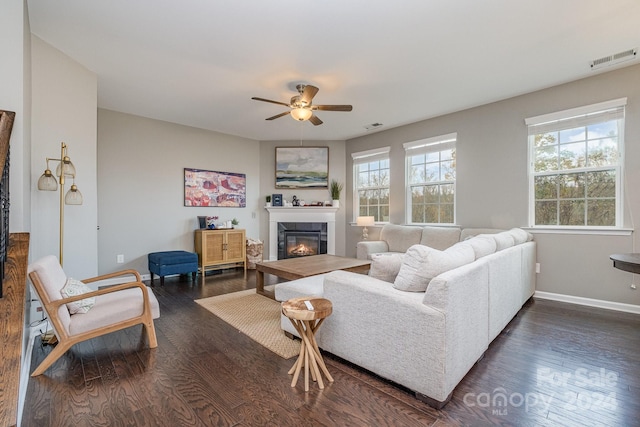 living room with ceiling fan, a tile fireplace, and dark hardwood / wood-style floors