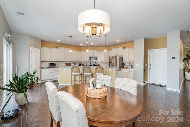 dining space featuring dark hardwood / wood-style flooring and a chandelier