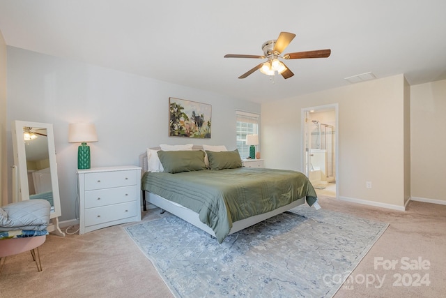 bedroom featuring light colored carpet, ceiling fan, and connected bathroom