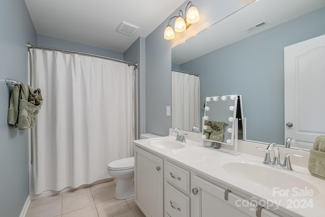 bathroom with toilet, vanity, and tile patterned flooring